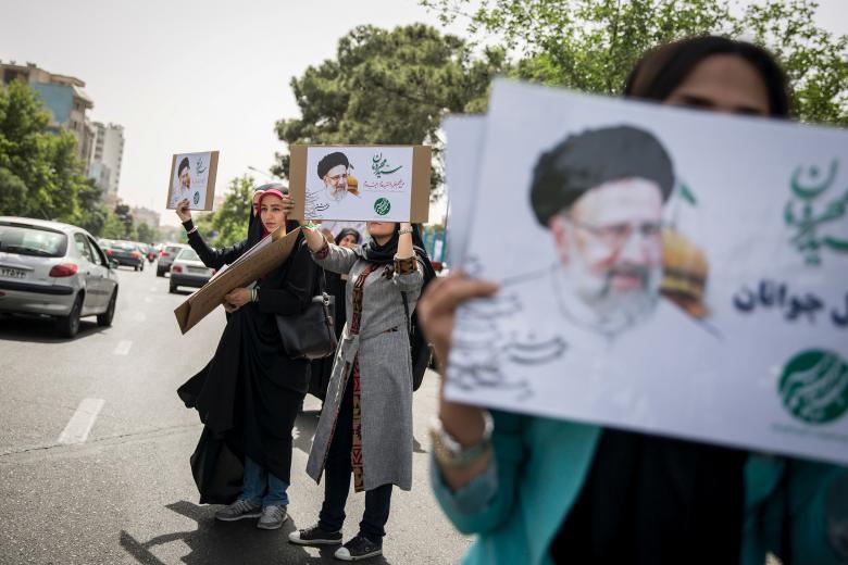 Supporters of Iranian presidential candidate Ebrahim Raisi hold his posters outside the Mosalla mosque in Tehran, Iran, May 16, 2017.