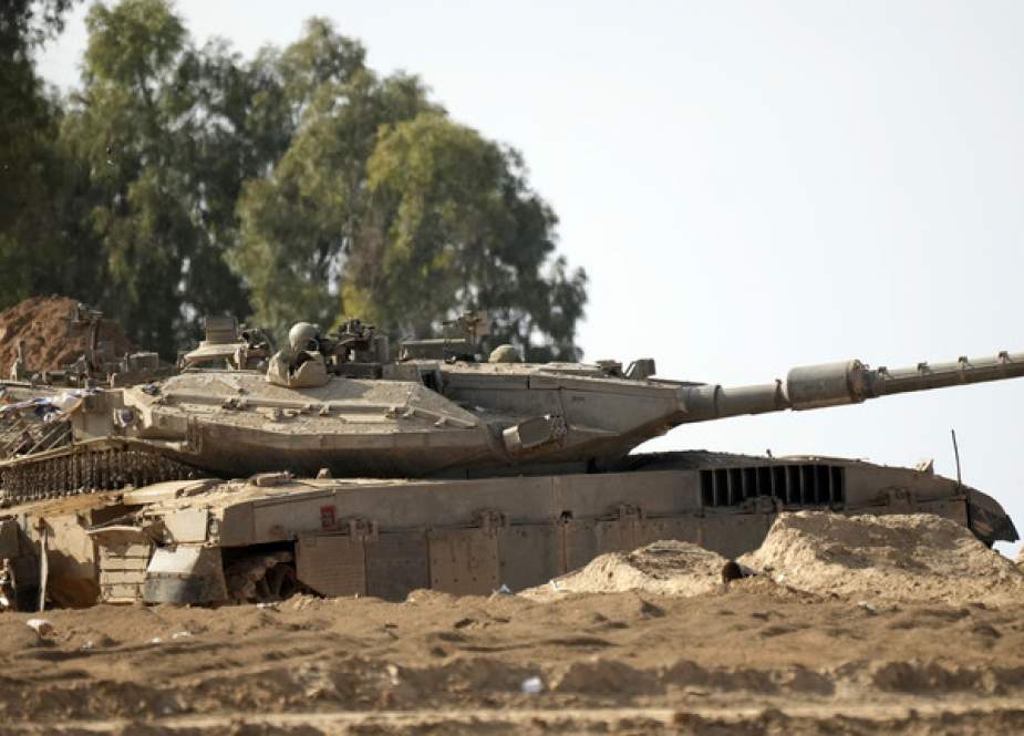 Israeli tank stands in a staging area near the border with Gaza