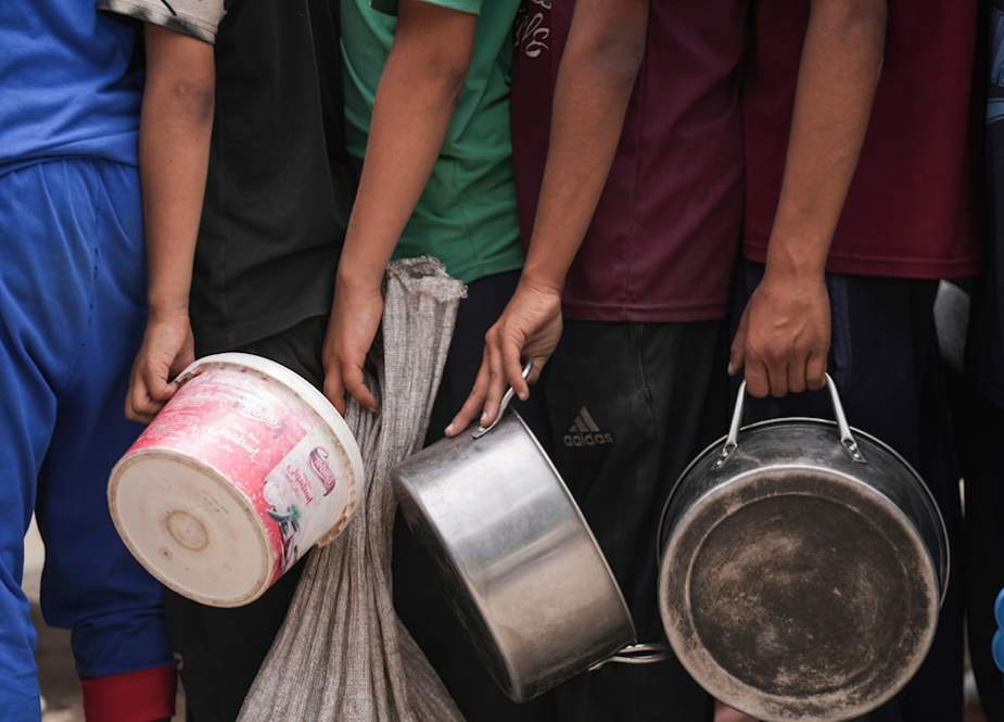 Palestinians line up for food distribution in Dier Balah, Gaza Strip