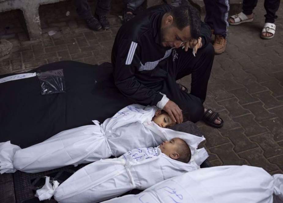 Ashraf Abu Draz mourns over the bodies of his two daughters who were killed in the Israeli bombardment of the Gaza Strip