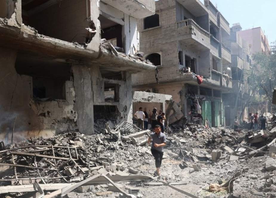 A man runs on the rubble of destroyed buildings following operations by the Israeli Special Forces in Nuseirat, Gaza