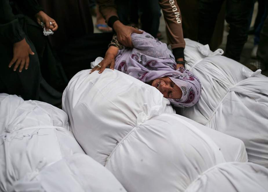 Palestinians mourn over the bodies of relatives killed in an Israeli airstrike outside the morgue in Al-Aqsa Martyrs Hospital in Deir al-Balah, the Gaza Strip