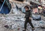A girl walks through rubble in an area hit by Israeli bombardment in Rafah