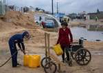 Palestinians-displaced-by-the-Israeli-airstrikes-in-Gaza-gather-water-in-a-makeshift-tent-camp-in-Ra