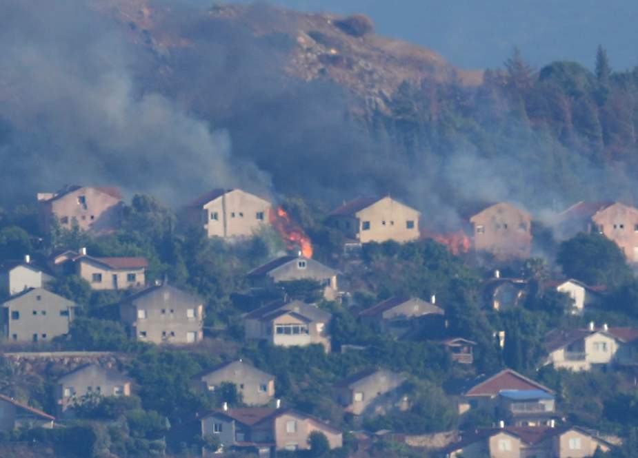 Fires and smoke rise at houses in the northern occupied Palestinian border town of Metula