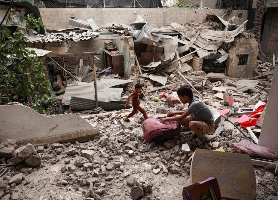 A Palestinian child salvages objects amid the debris of a house destroyed by overnight Israeli bombardment in Rafah, Gaza Strip
