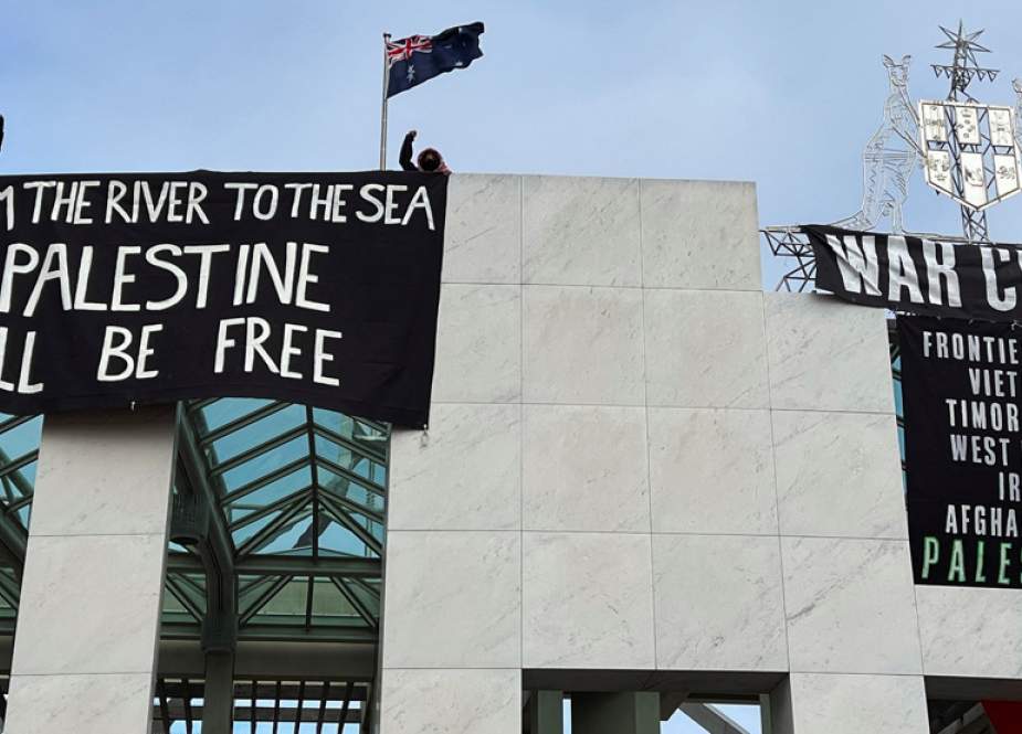 Pro-Palestinian protesters hang banners on the roof of Australia’s Parliament House building in Canberra, Australia