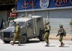 Israeli occupation officers walk back to their vehicles in the Palestinians al-Fara’a refugee camp, West Bank