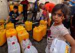 Palestinian children fill up containers with water in Gaza City