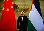 A staff member checks the alignment of Chinese, and Palestinian flags