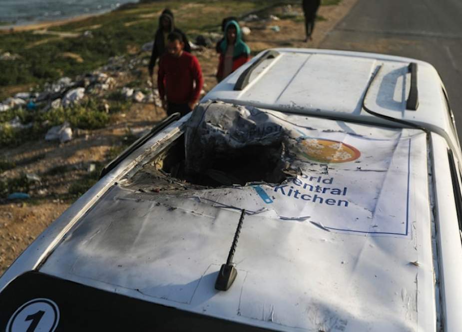 Palestinians inspect a vehicle with the logo of the World Central Kitchen wrecked by an Israeli occupation airstrike in Deir al Balah, Gaza Strip